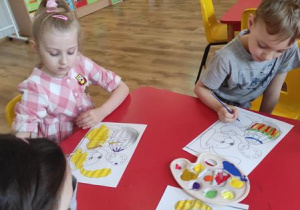 Dzieci malują wielkanocne obrazki.